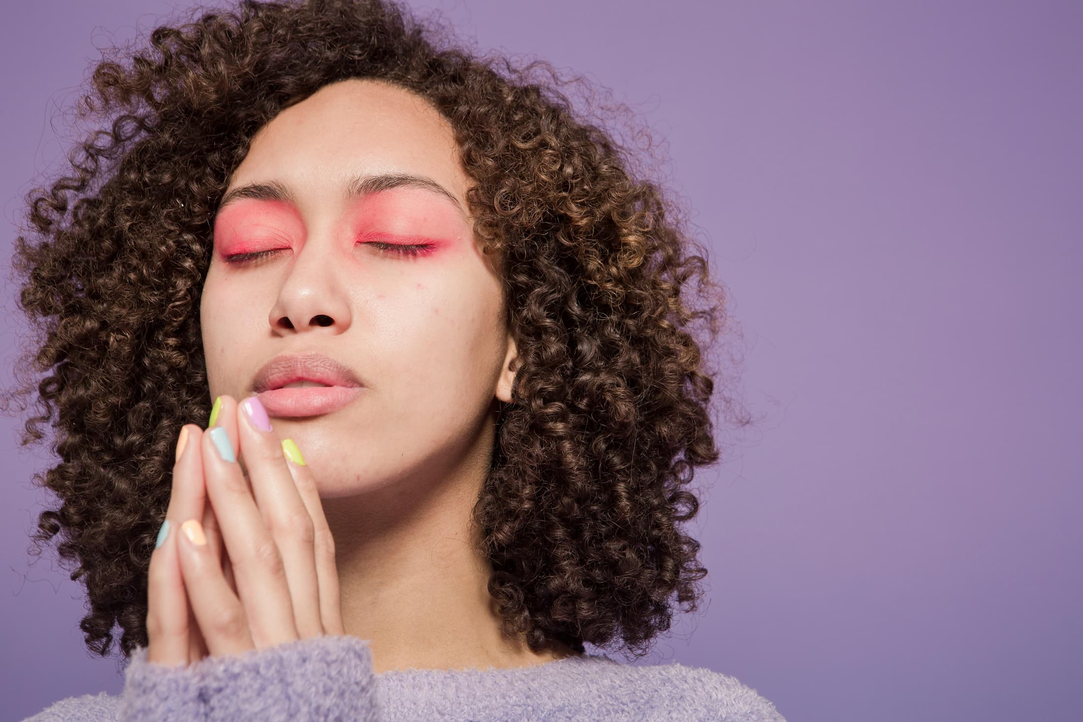 a-person-holding-their-hands-together-with-eyes-closed-working-on-manifestation