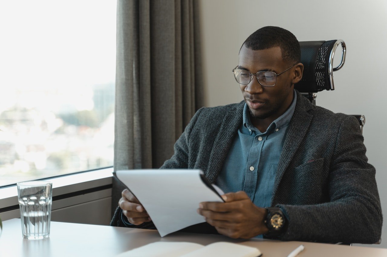 business-man-sitting-at-his-desk-looking-at-resumes-how-to-change-careers