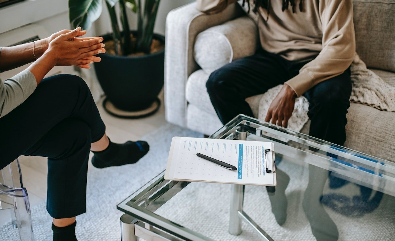 close-up-of-man-and-woman-legs-at-therapist-office-talking-relationship-coaching