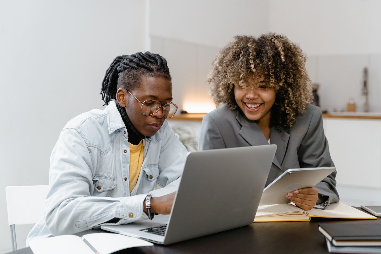 Coworkers-Having-Conversation-in-front-of-a-laptop-interpersonal-communication