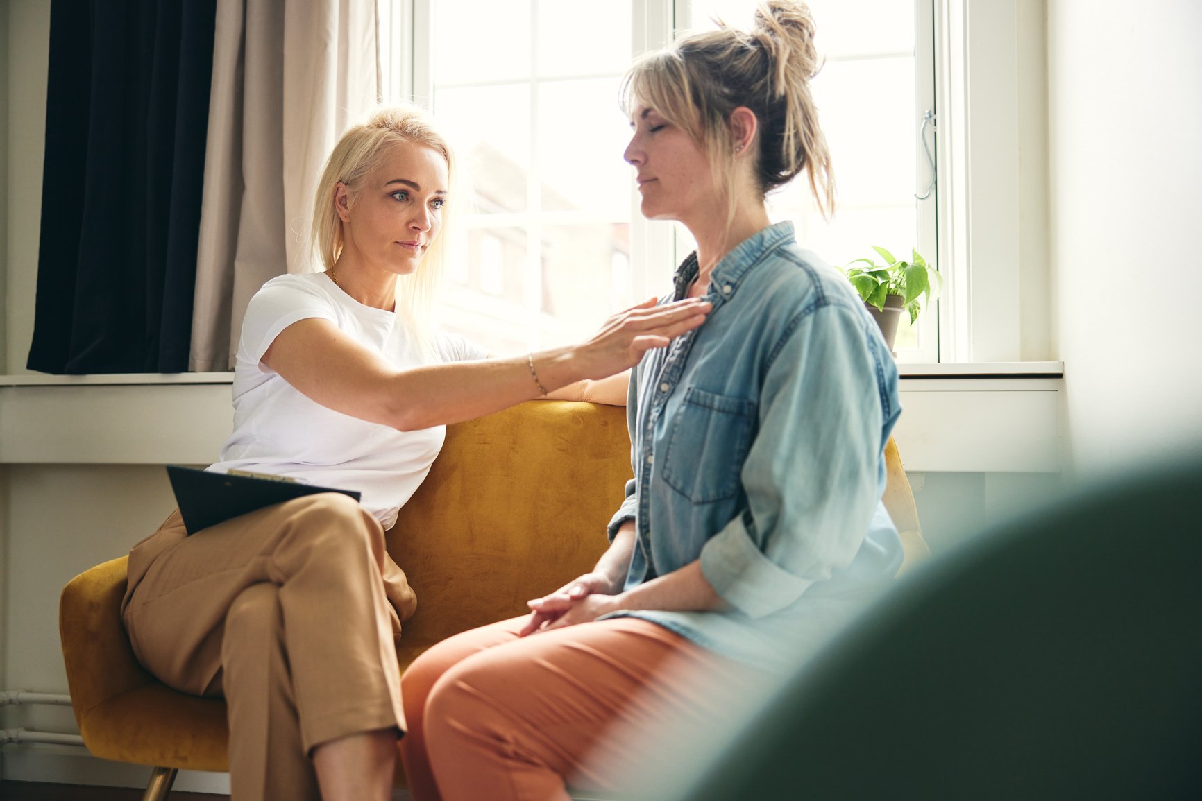 Female-coach-performing-touch-therapy-on-a-client-during-session-wellness-coaching