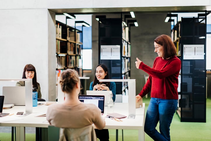 woman-stands-at-table-in-team-room-nonverbal-communication
