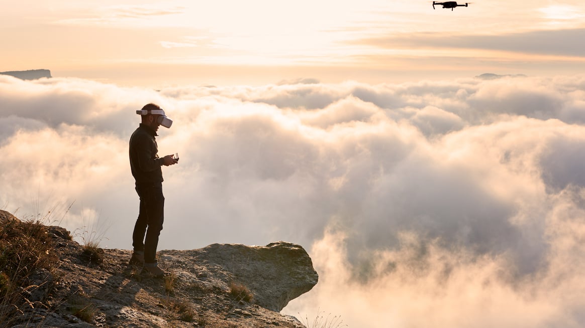 man-in-VR-goggles-stands-on-edge-of-cliff-outsmart-innovators-bias