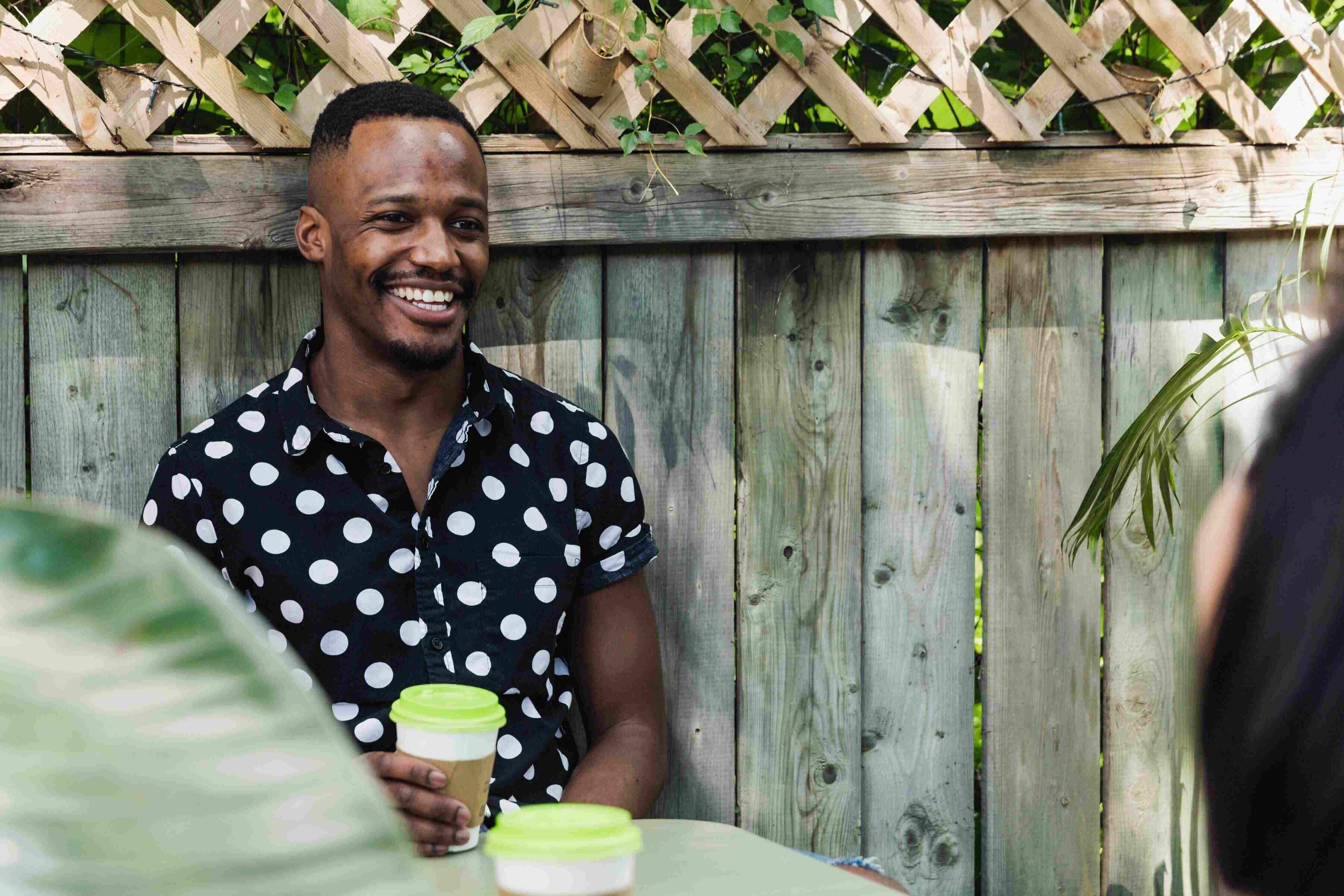 man drinking coffee is polka dot shirt