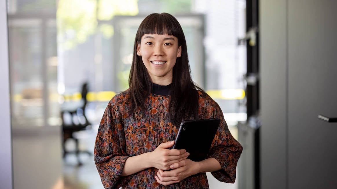 new-manager-training-woman-holding-laptop-smiling