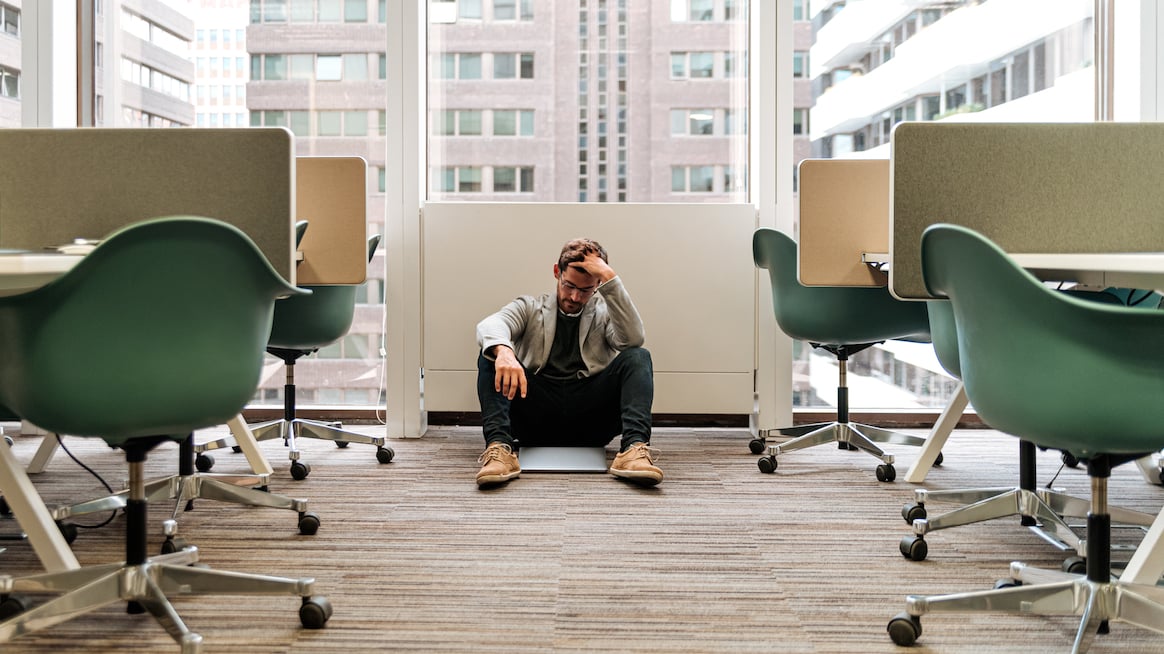 man-sits-on-office-floor-skills for effectively managing stress