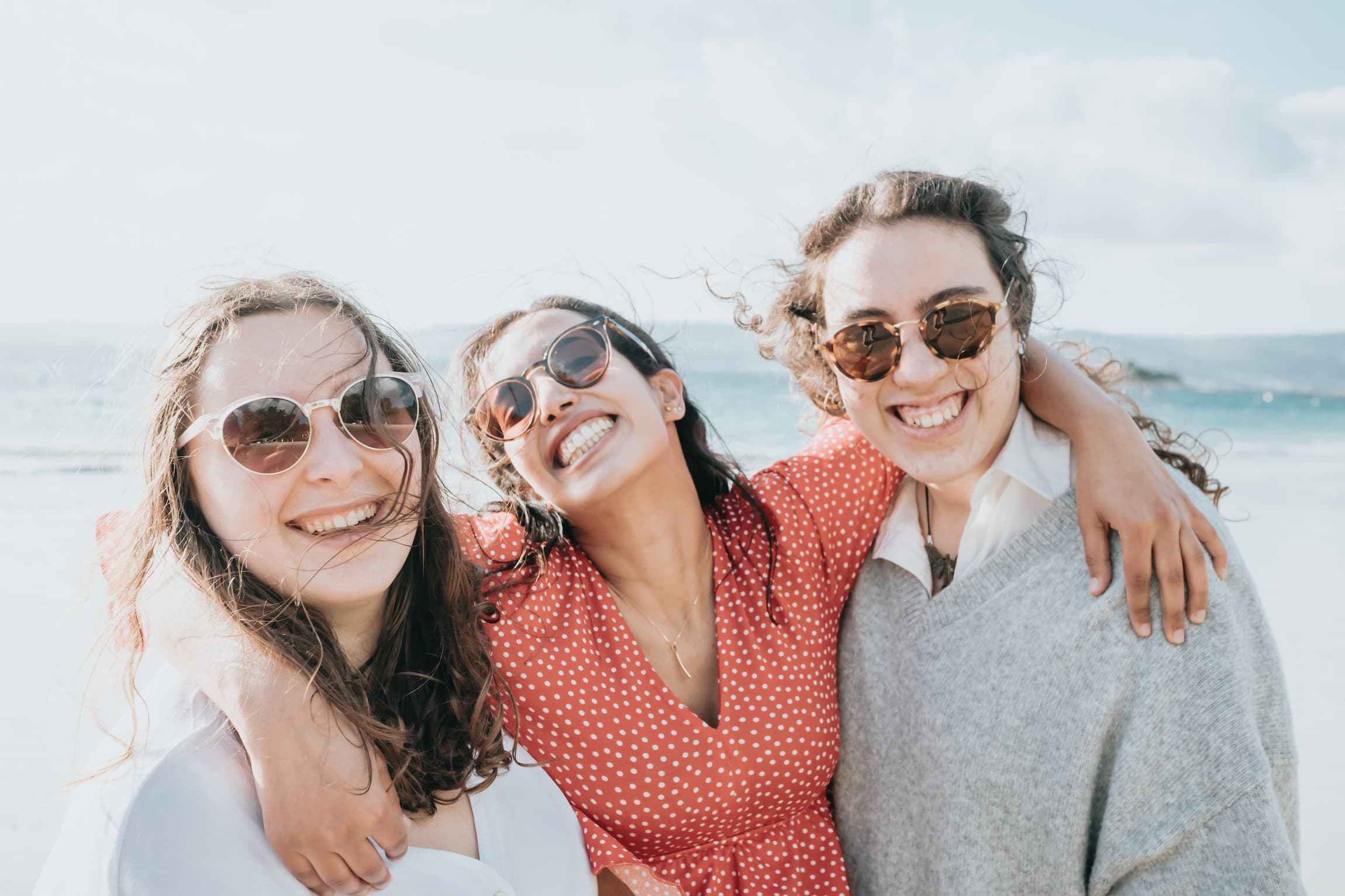 three-woman-in-sunglasses-smile-on-the-beach-after-learning-about-the-16-personalities
