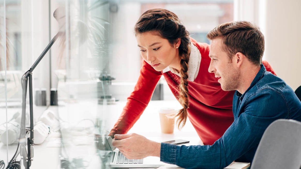 transformational-leadership-coworkers-talking-at-computer