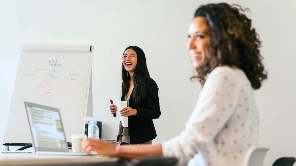 what-is-career-coaching-two-women-in-meeting-laughing