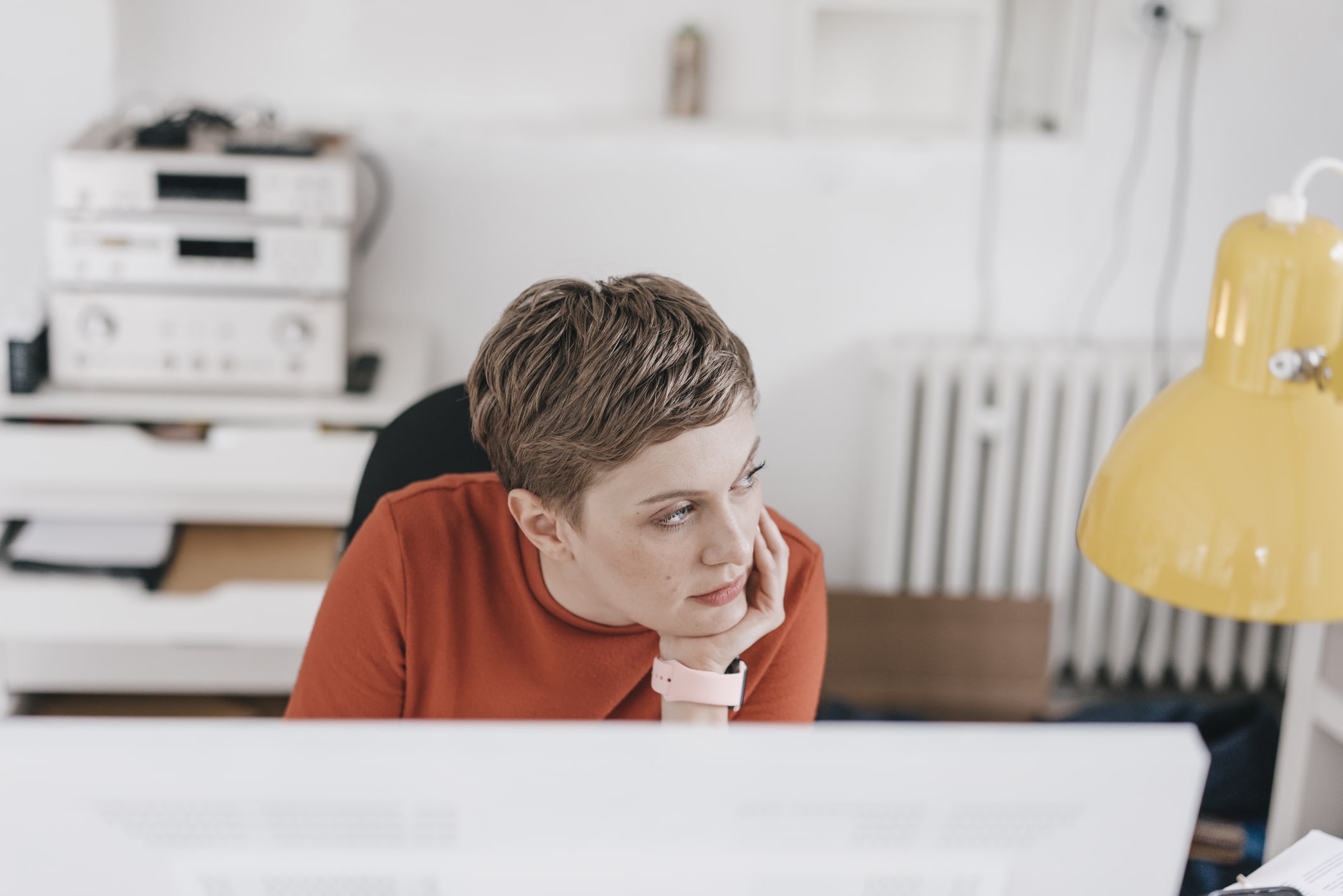 Woman-at-desk-in-office-thinking-why-cant-i-focus-on-anything