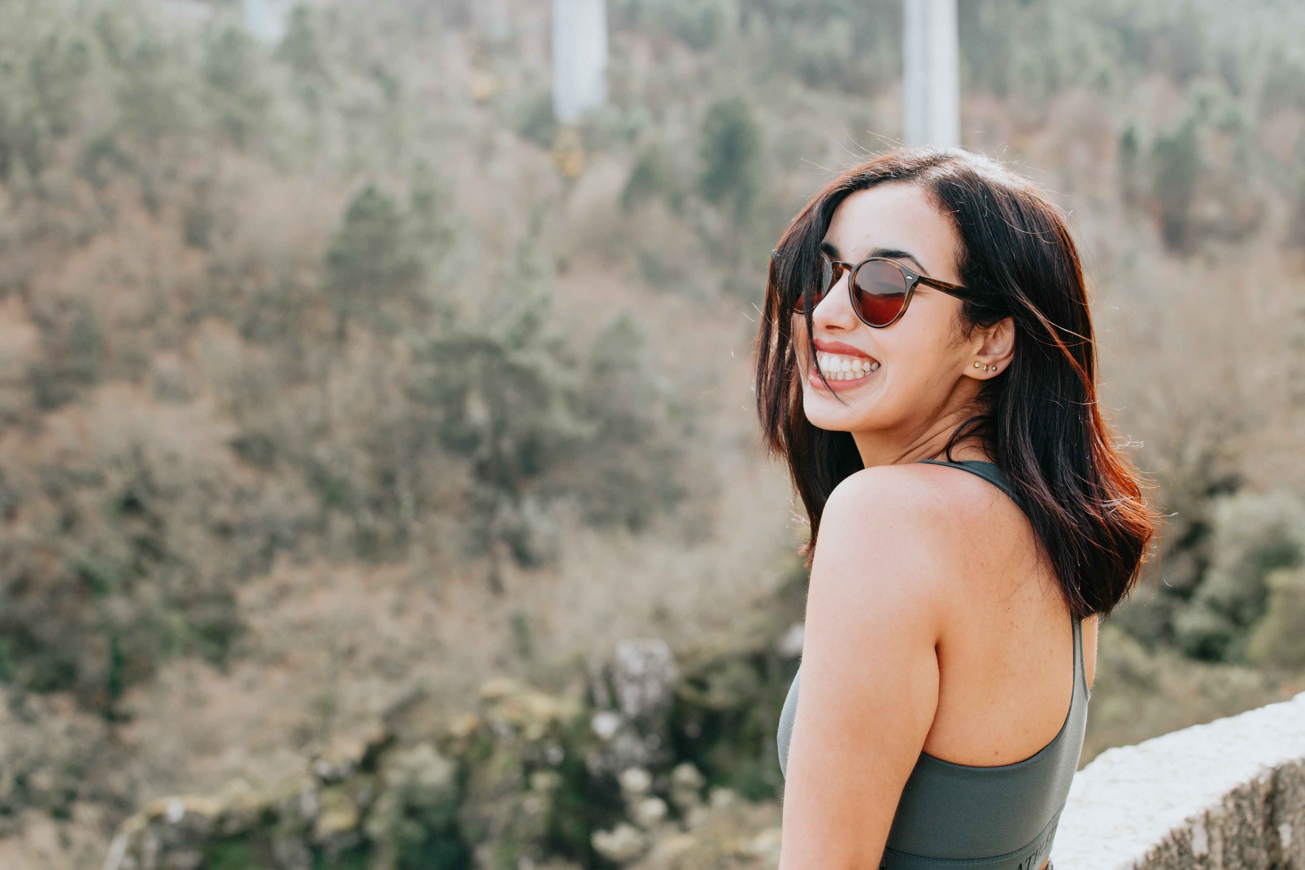 woman with sun glasses smiling into the distance
