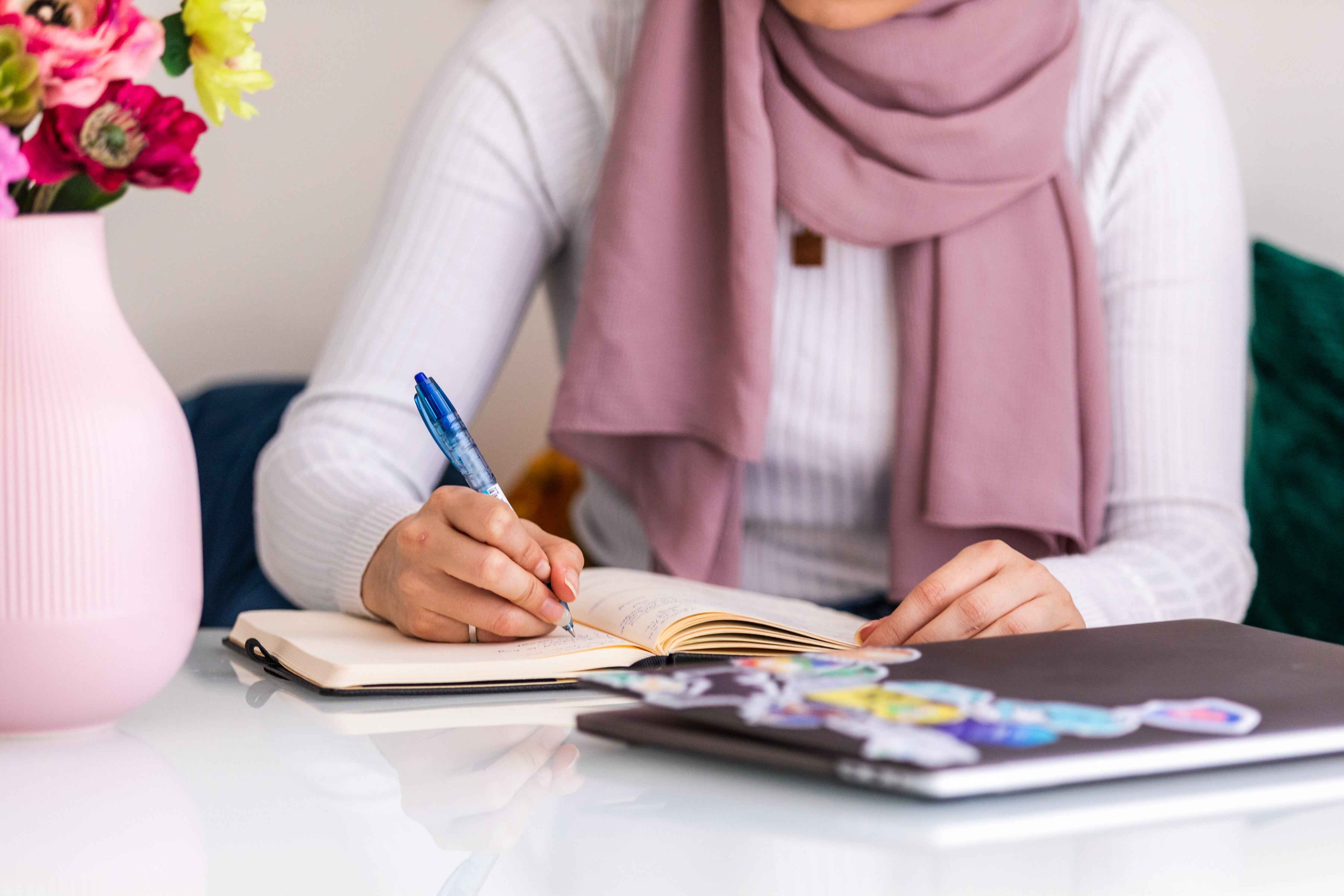 woman sitting and writing in a journal