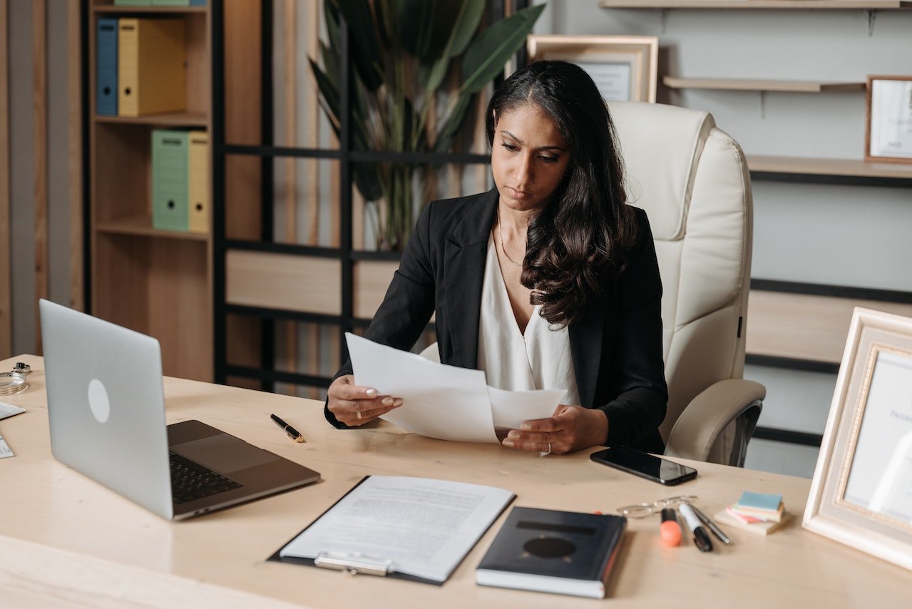 woman-sitting-in-desk-reviewing-contract-career-transition-coach